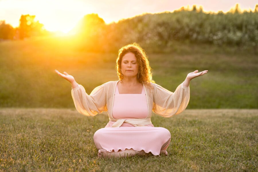 Jillian Johnson the owner of Simply J Bookkeeping & Consulting mediating in an open field during a sunset.